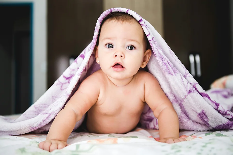 Slapende pasgeboren baby onder een zachte deken